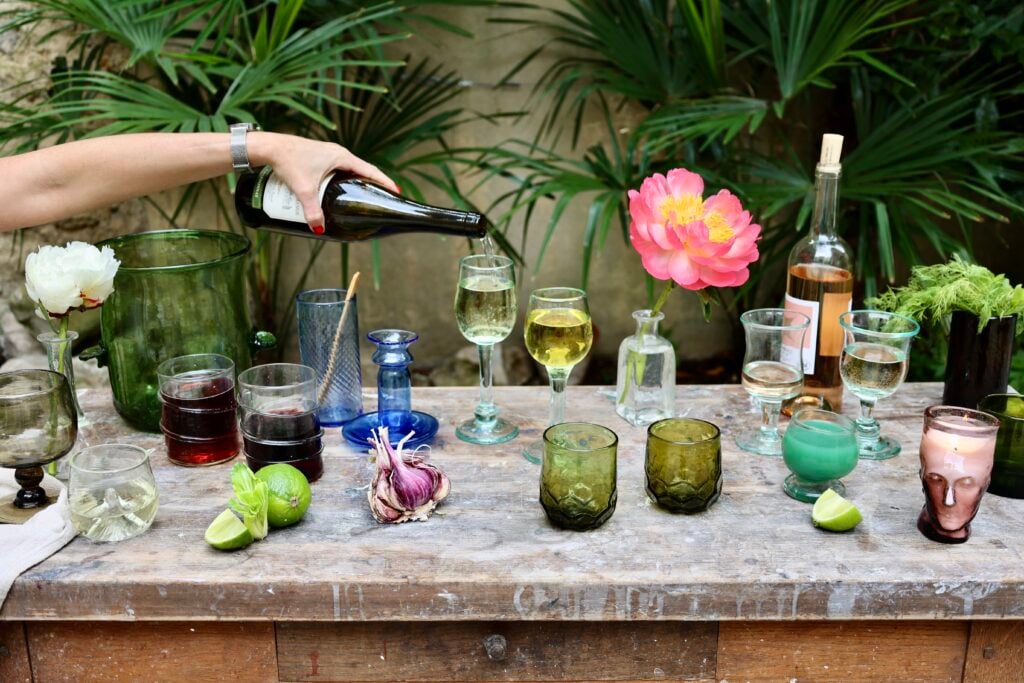 la-soufflerie-recycled-glassware-on-table-with-hand-pouring-red-wine